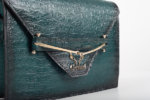 CLUTCH BAG WITH DECORATIVE METAL ACCESSORIES AND HANDLE IN DARK GREEN