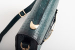 CLUTCH BAG WITH DECORATIVE METAL ACCESSORIES AND HANDLE IN DARK GREEN