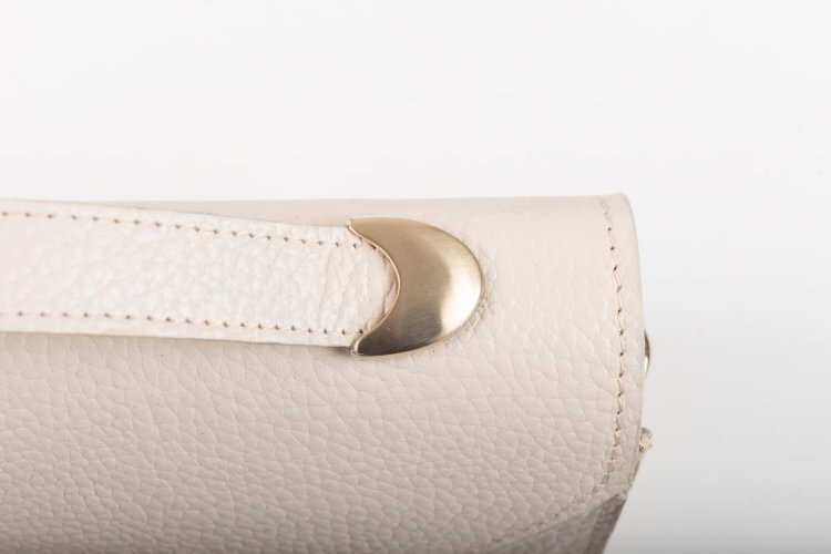 CLUTCH BAG WITH DECORATIVE METAL ACCESSORIES AND HANDLE IN CREAM